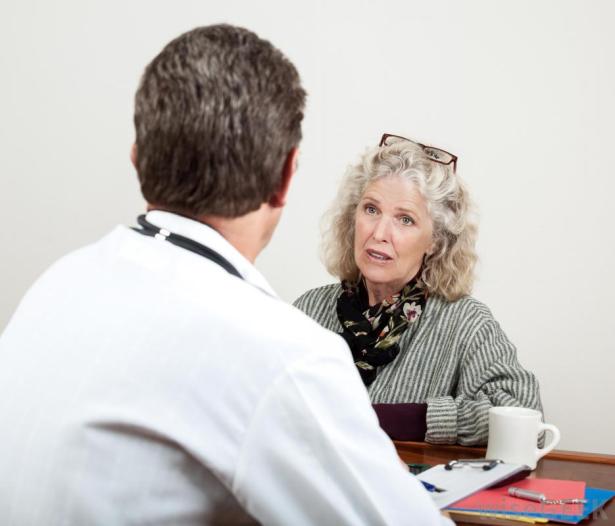 back-of-male-doctor-looking-at-older-female-patient